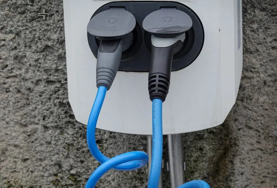 Borne de recharge installée dans un garage, voiture électrique branchée, éclairage doux et ambiance domestique